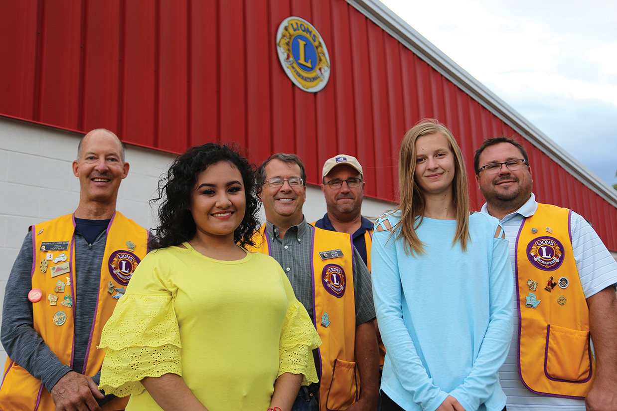 Scholarship recipients Fatima Leon Cuevas (left) and Erin Goodson with members of the Greenville Lions Club